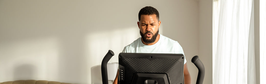 man looking at the screen of a max trainer