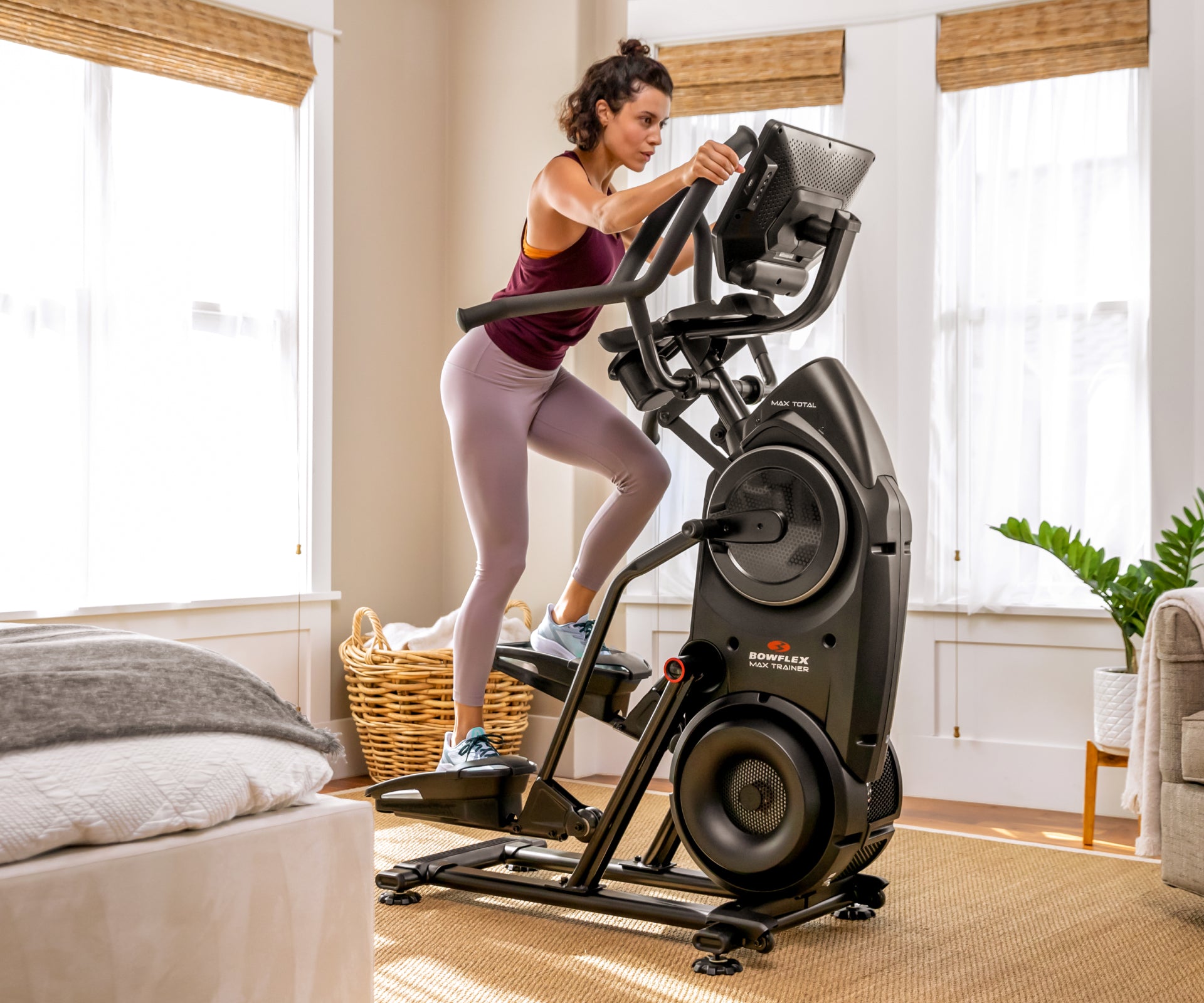 Woman exercising on BowFlex Max Total 16 in a home setting.