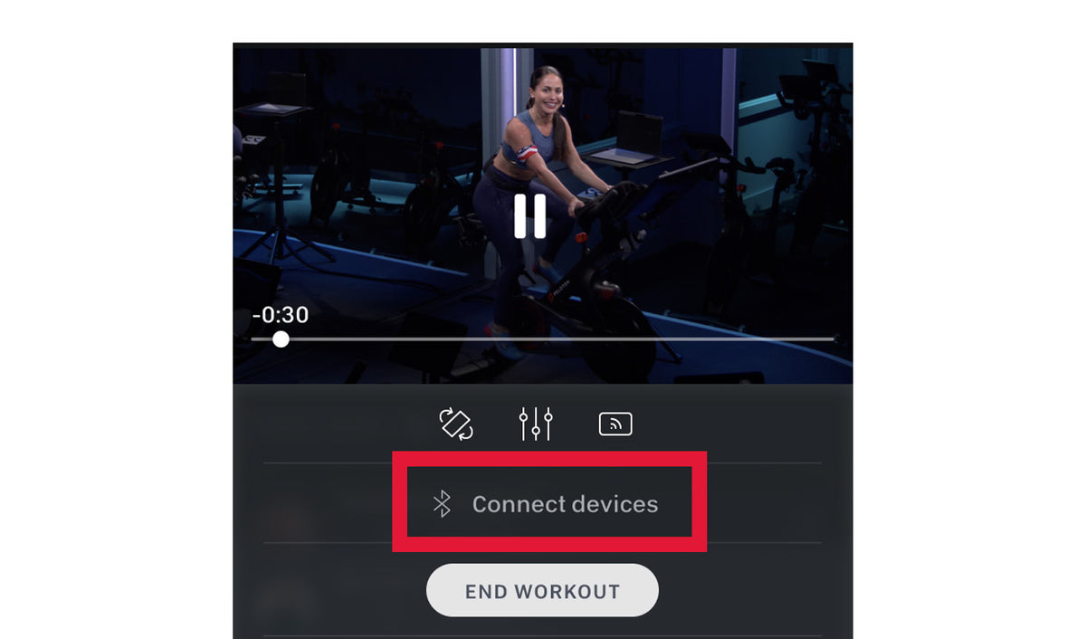 A screenshot of the Peloton app showing a paused indoor cycling workout with a highlighted 'Connect devices' button and an 'END WORKOUT' button below.