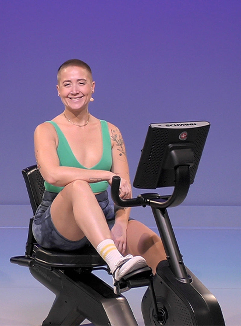 Person smiling while sitting on a Schwinn Recumbent Bike.