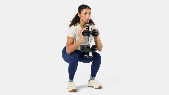 BowFlex Results Series 90 SelectTech Dumbbells - woman doing a squat with dumbbell