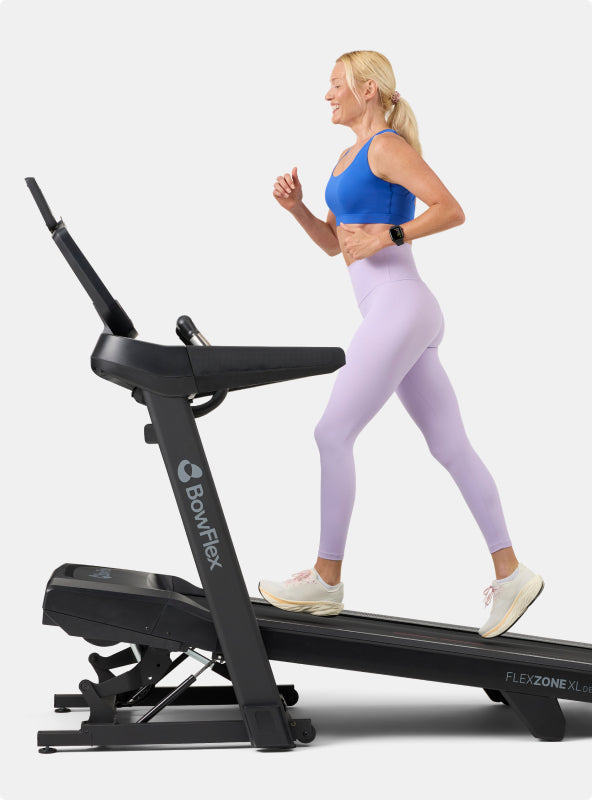 Woman running on an inclined BowFlex T16 Treadmill.