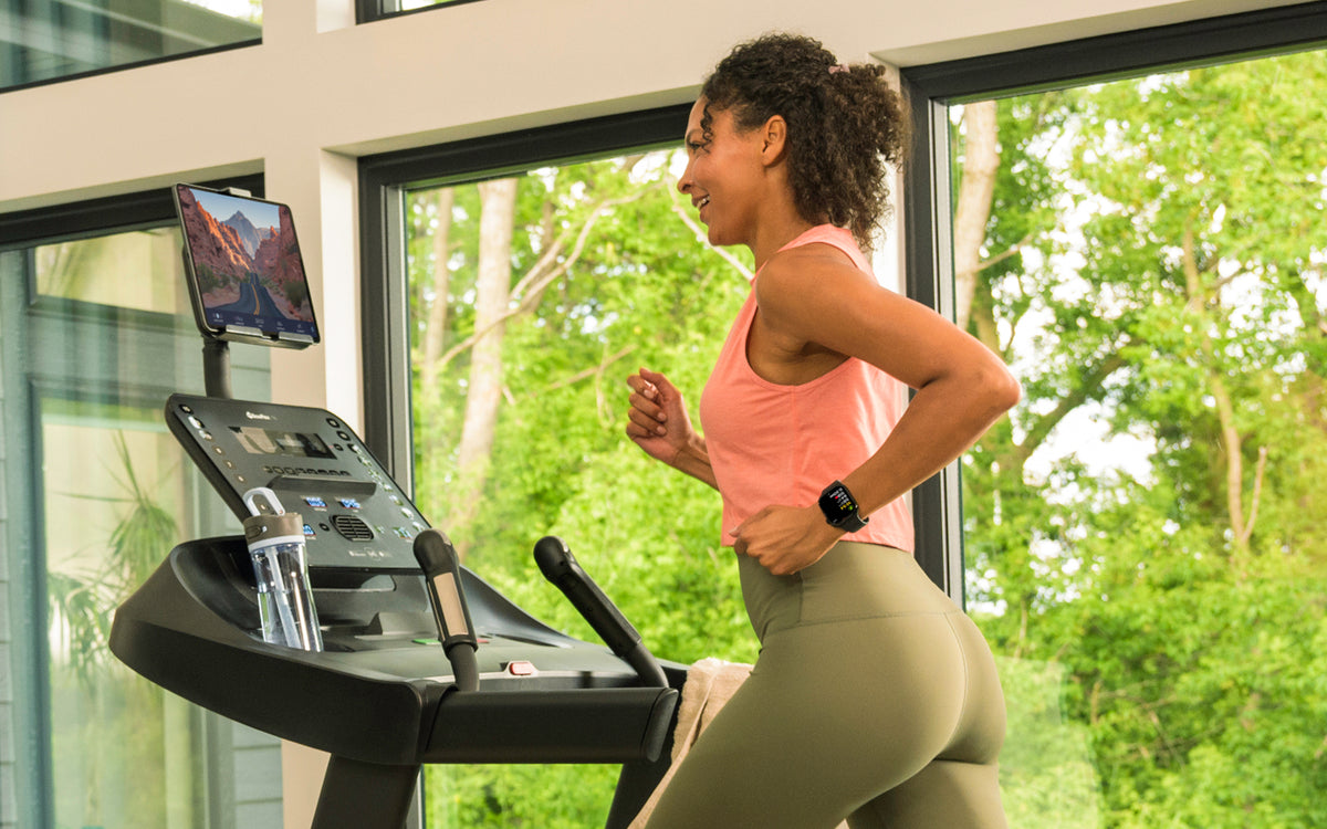Woman using a BowFlex T6 Treadmill with the JRNY fitness app