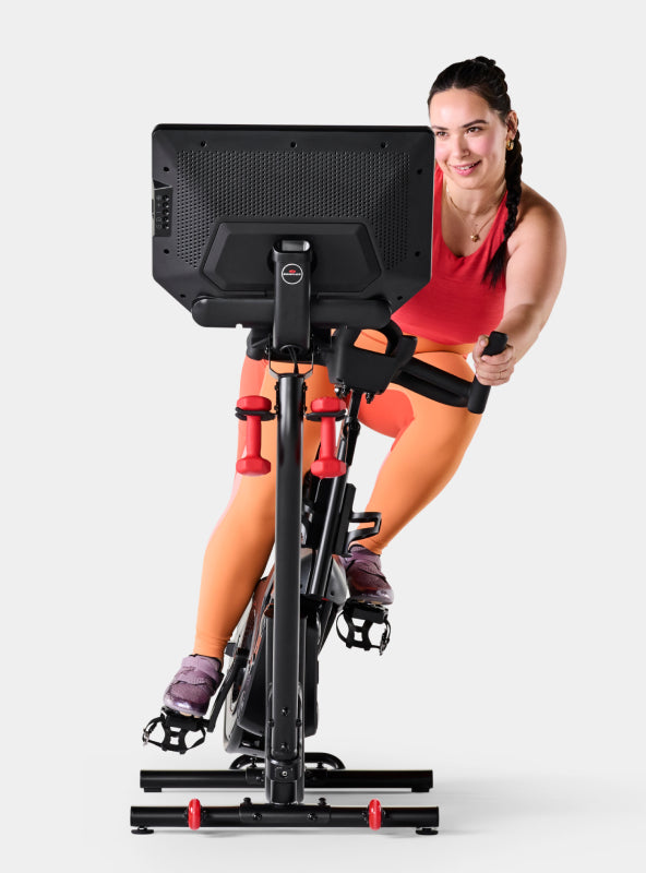 Woman riding the BowFlex VeloCore Bike 22 in leaning mode.