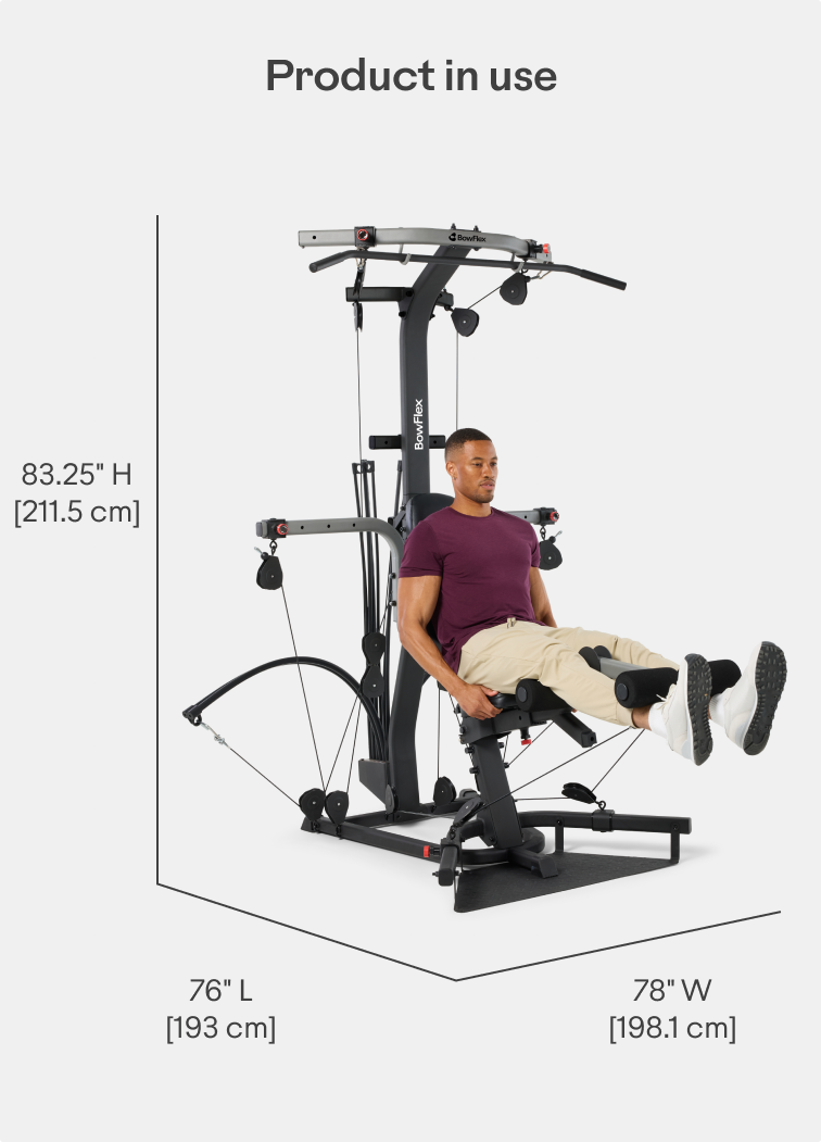 Man seated on the BowFlex Xtreme 2 SE Home Gym, working out using its leg extension system.