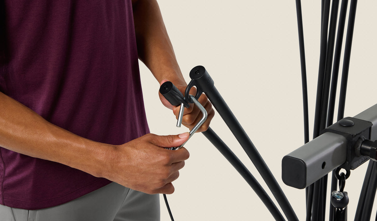 Hands adjusting the Power Rod® resistance weight on the BowFlex 
Xtreme 2 SE Home Gym.